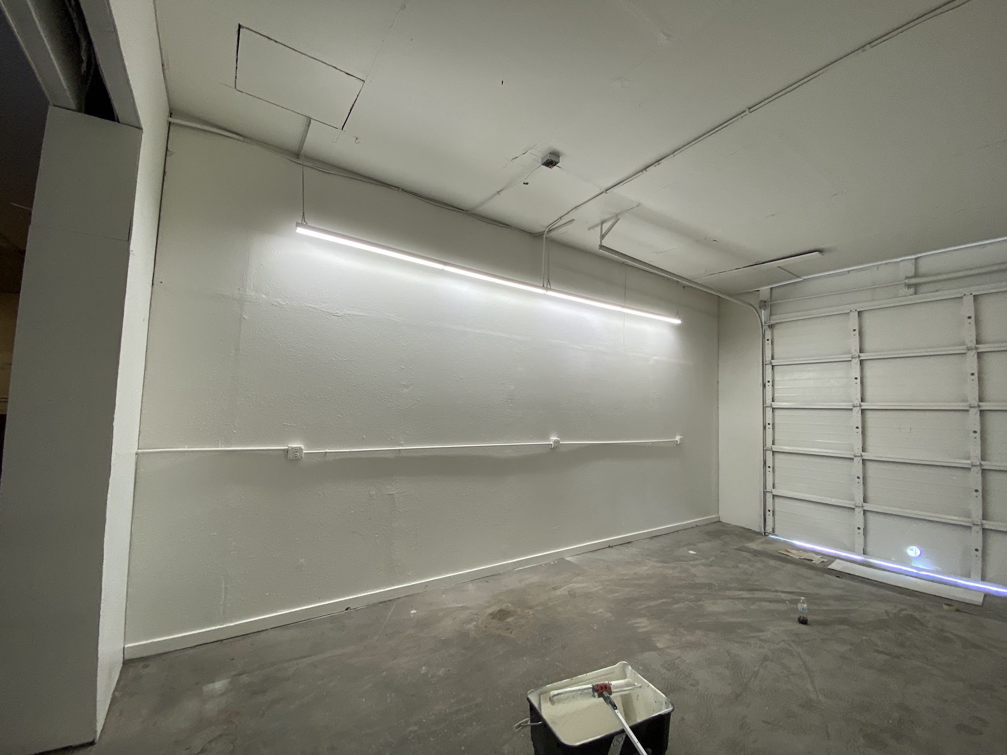 Garage interior mid repaint with fresh white walls